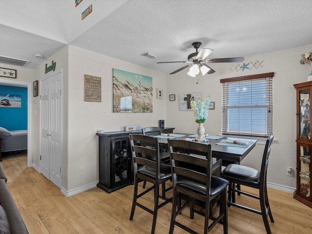 dining space featuring a textured ceiling, light hardwood / wood-style floors, and ceiling fan