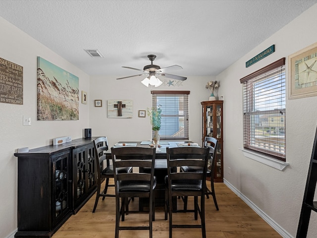 dining room featuring a textured ceiling, hardwood / wood-style floors, ceiling fan, and a wealth of natural light