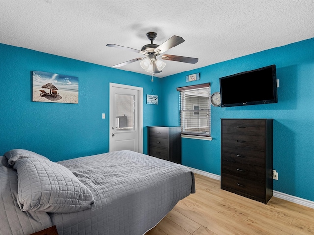 bedroom with light wood-type flooring, a textured ceiling, and ceiling fan