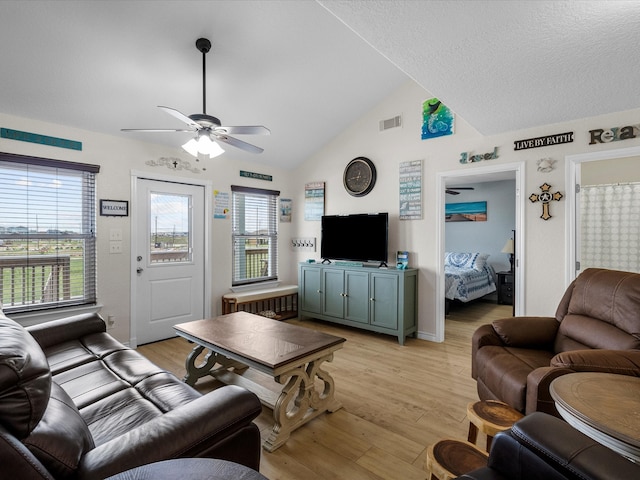 living room featuring light hardwood / wood-style floors, lofted ceiling, ceiling fan, and plenty of natural light