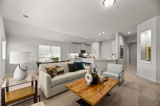 carpeted living room featuring sink