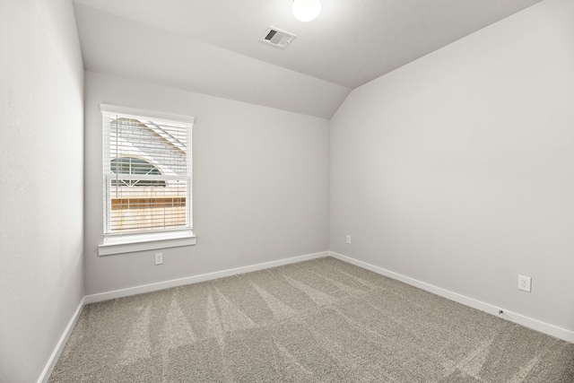 carpeted empty room with lofted ceiling