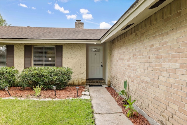 entrance to property featuring a lawn