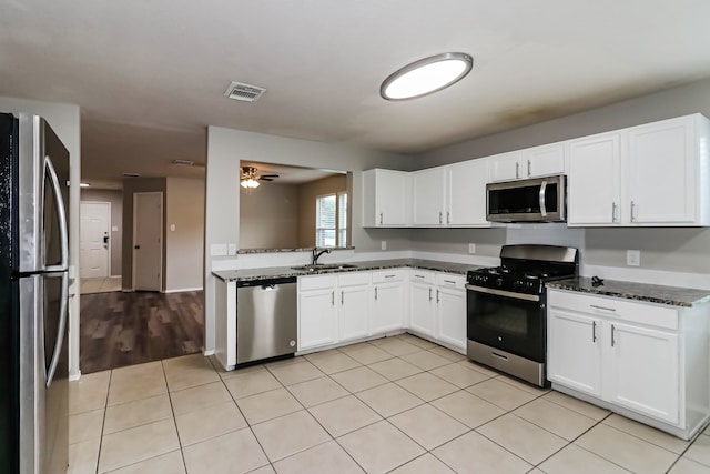 kitchen featuring appliances with stainless steel finishes, white cabinetry, and sink