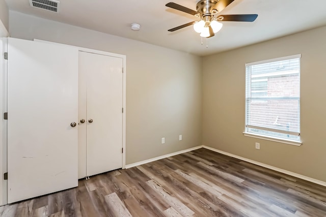 unfurnished bedroom with ceiling fan and dark hardwood / wood-style flooring