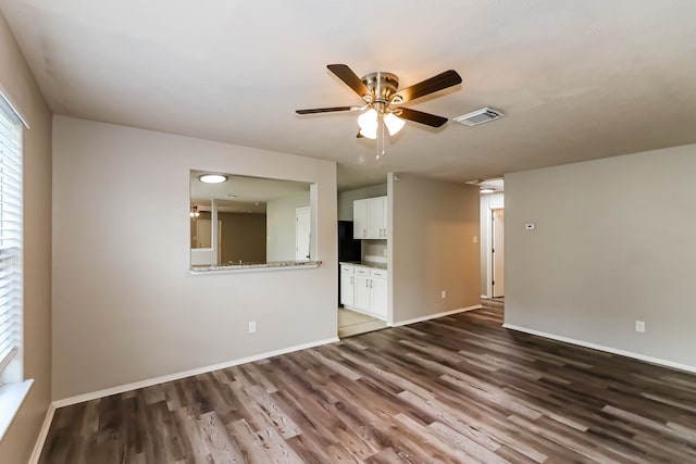 empty room featuring dark wood-type flooring and ceiling fan