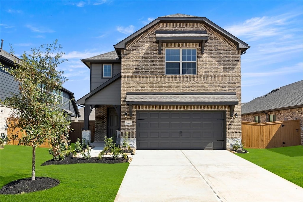 view of front of property featuring a front lawn, fence, brick siding, and driveway