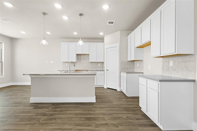 kitchen with visible vents, dark wood finished floors, an island with sink, recessed lighting, and white cabinets