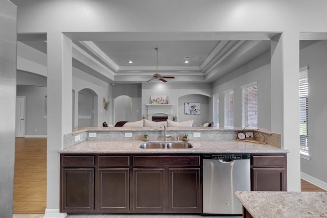 kitchen featuring light hardwood / wood-style floors, a raised ceiling, dishwasher, ornamental molding, and sink