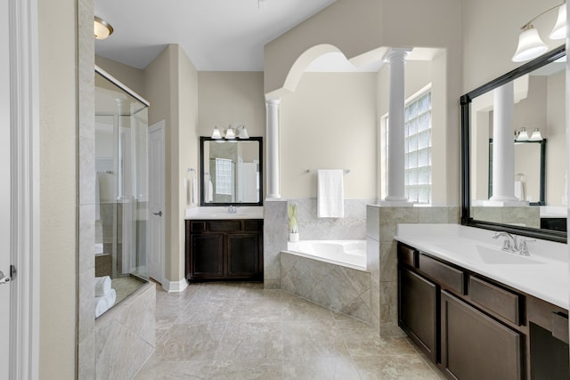 bathroom with independent shower and bath, vanity, and ornate columns