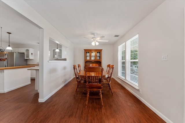 dining room with ceiling fan and dark wood-type flooring