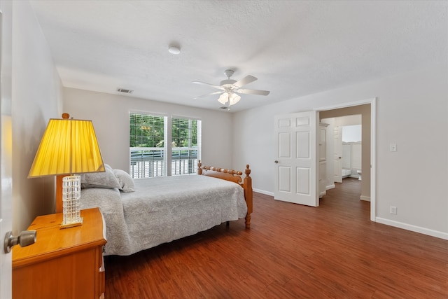 bedroom featuring a textured ceiling, ceiling fan, and dark wood-type flooring