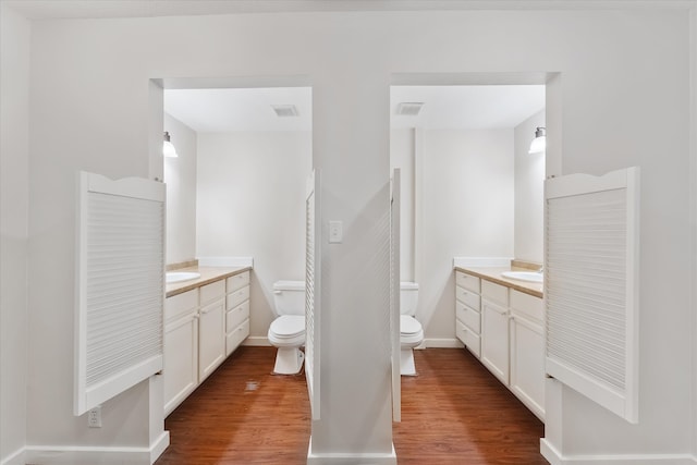 bathroom with hardwood / wood-style floors, vanity, and toilet