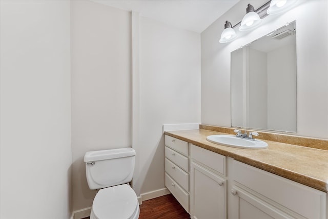 bathroom with hardwood / wood-style floors, vanity, and toilet