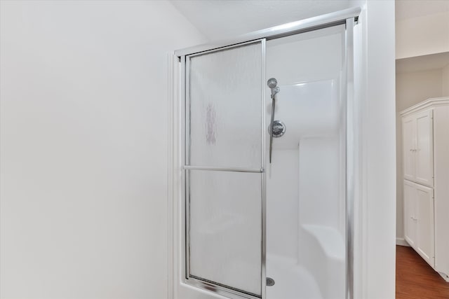 bathroom featuring hardwood / wood-style flooring and an enclosed shower