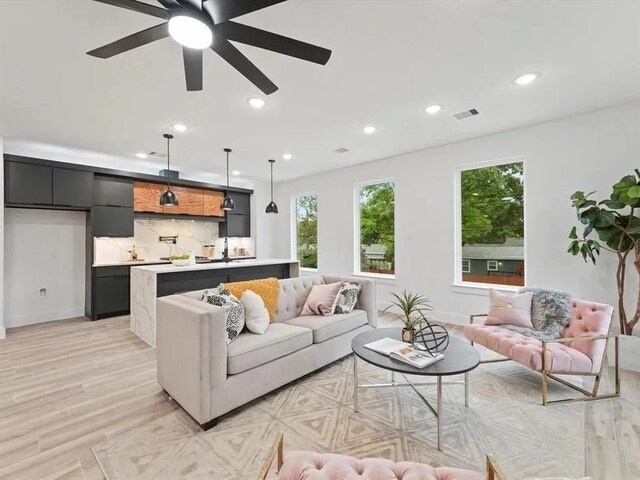 living room with light hardwood / wood-style flooring and ceiling fan