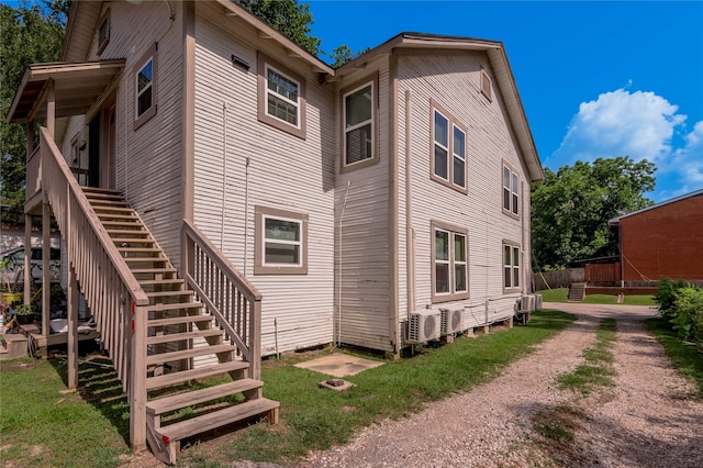 rear view of property featuring a yard and central AC unit