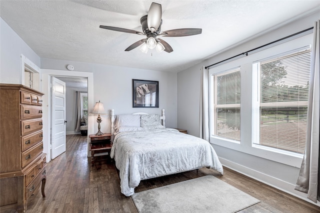 bedroom featuring a textured ceiling, ceiling fan, and dark hardwood / wood-style flooring