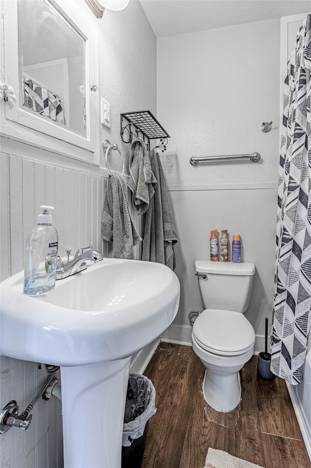 bathroom with a shower with shower curtain, toilet, hardwood / wood-style flooring, and sink