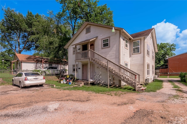 view of front of property with cooling unit and a front lawn