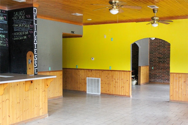 exterior space with ceiling fan, wooden walls, crown molding, and wooden ceiling