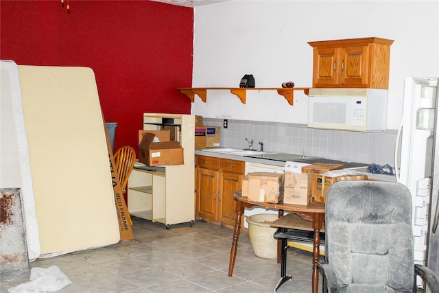 kitchen with sink, light tile patterned floors, white appliances, and decorative backsplash