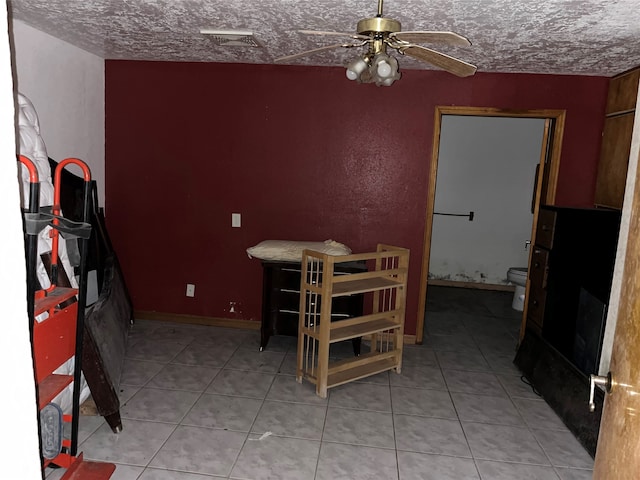 dining space featuring ceiling fan, light tile patterned floors, and a textured ceiling