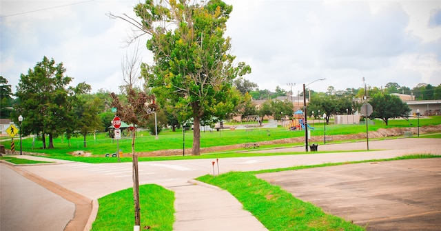 view of community featuring basketball hoop and a lawn