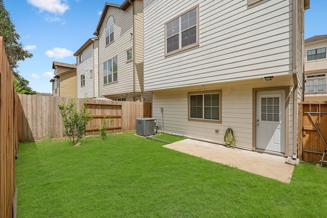 back of property with a lawn, a patio, and central AC unit