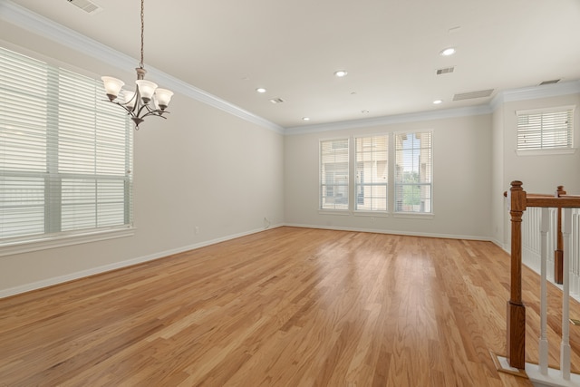 spare room with crown molding, light wood-type flooring, and a chandelier