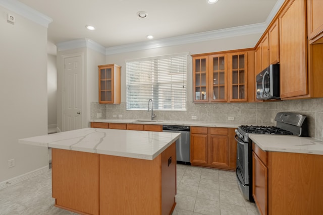 kitchen featuring appliances with stainless steel finishes, light stone countertops, sink, a kitchen island, and decorative backsplash