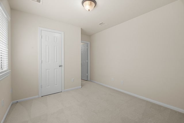 unfurnished bedroom featuring multiple windows and light carpet