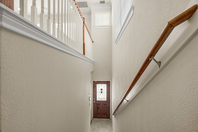 stairway featuring a towering ceiling and plenty of natural light