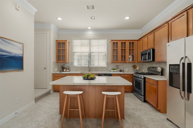 kitchen with stainless steel appliances, sink, a center island, and a kitchen breakfast bar