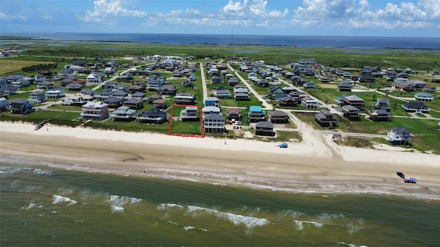 drone / aerial view featuring a beach view and a water view