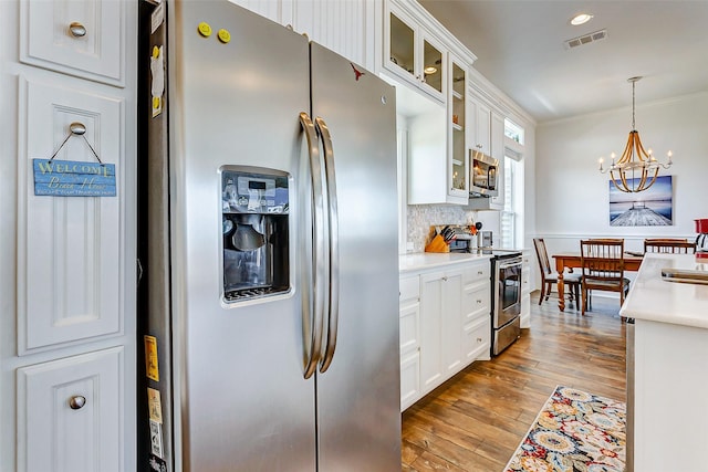 kitchen with visible vents, white cabinets, wood-type flooring, stainless steel appliances, and light countertops