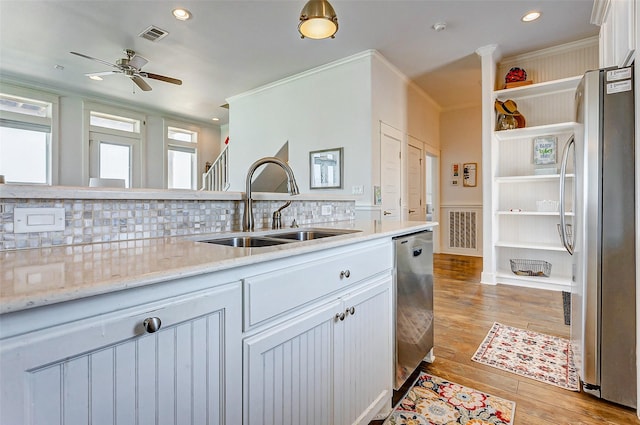 kitchen with white cabinets, stainless steel appliances, light wood-type flooring, open shelves, and a sink