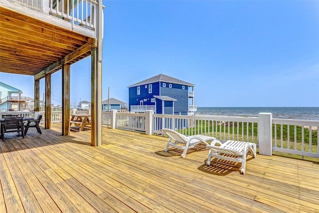 wooden terrace featuring outdoor dining area and a water view