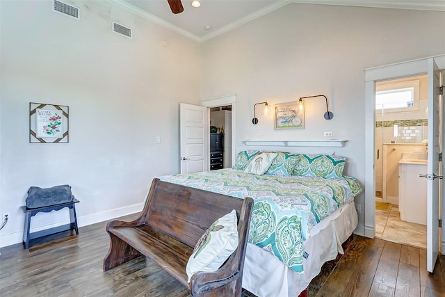 bedroom with ornamental molding, wood finished floors, visible vents, and baseboards