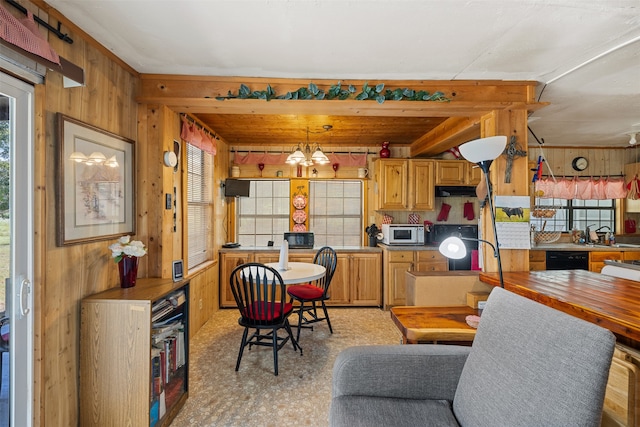 kitchen with black dishwasher, light colored carpet, wood walls, and a chandelier