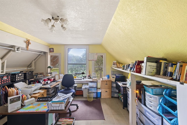 tiled office space featuring vaulted ceiling and a textured ceiling