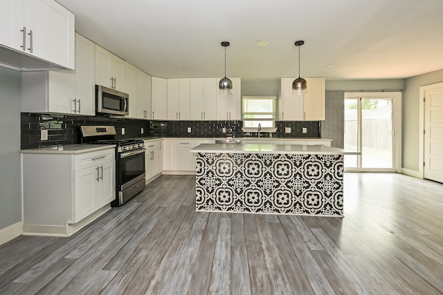 kitchen featuring a healthy amount of sunlight, dark hardwood / wood-style floors, appliances with stainless steel finishes, and white cabinetry