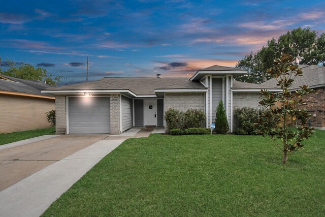 ranch-style home featuring a garage and a yard