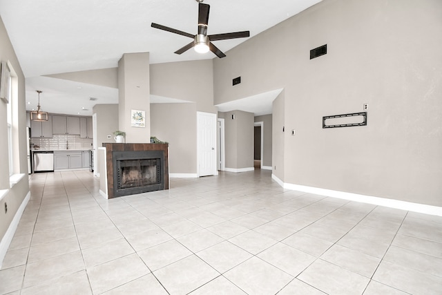 unfurnished living room with a fireplace, high vaulted ceiling, light tile patterned floors, and ceiling fan