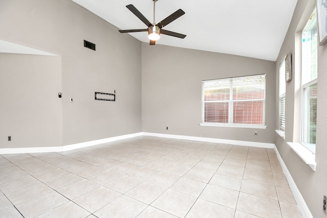 tiled empty room featuring high vaulted ceiling, ceiling fan, and plenty of natural light