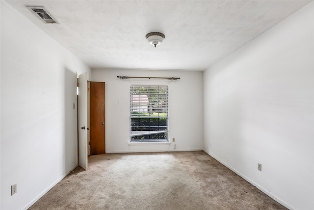 carpeted empty room with a textured ceiling