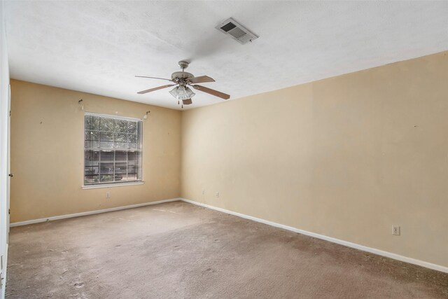 carpeted spare room featuring ceiling fan and a textured ceiling