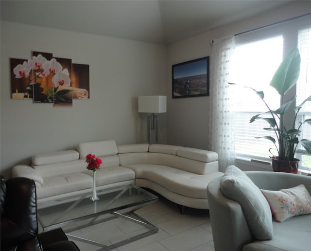 living room featuring lofted ceiling and light tile patterned floors