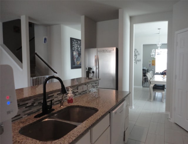 kitchen featuring white dishwasher, stone counters, white cabinetry, sink, and stainless steel fridge with ice dispenser