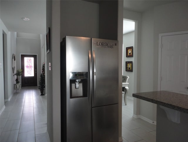 kitchen with light tile patterned floors and stainless steel fridge with ice dispenser